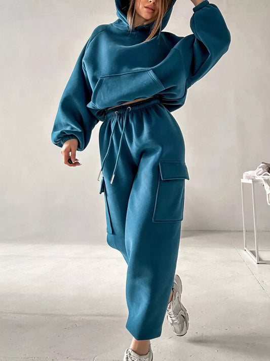 Woman wearing a teal hoodie and jogger pants two-piece set with pockets 