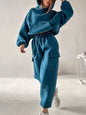 Woman wearing a teal hoodie and jogger pants two-piece set with pockets 