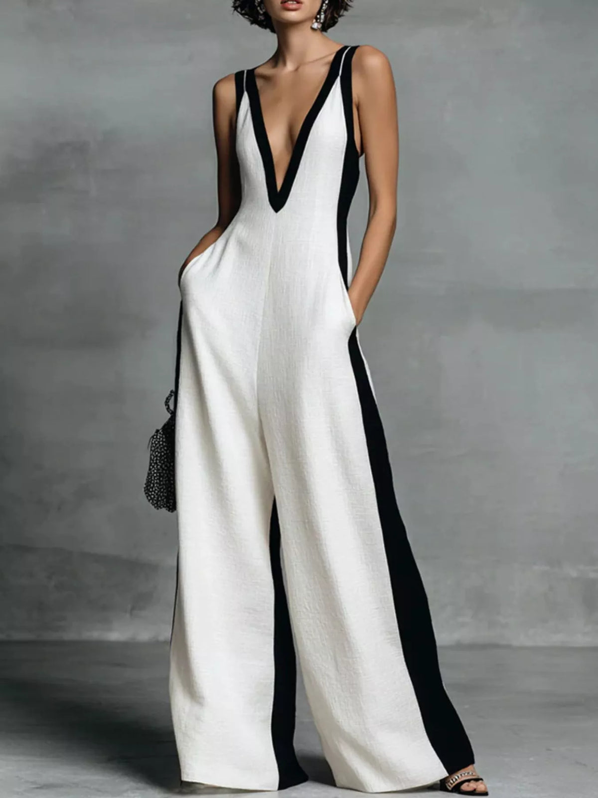 Woman wearing white wide leg sleeveless jumpsuit with deep v neck 