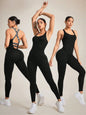 Woman wearing black strappy back workout jumpsuit.